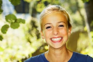 Smiling teenager shows off her dental crowns, also known as teeth crowns, available to patients in Spanish Springs and Reno.